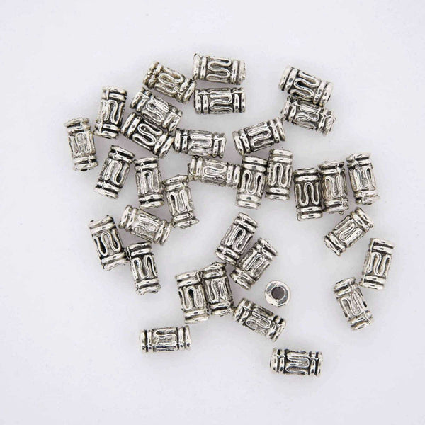 Silver plated jewelry finding tube beads with squiggly patterns.