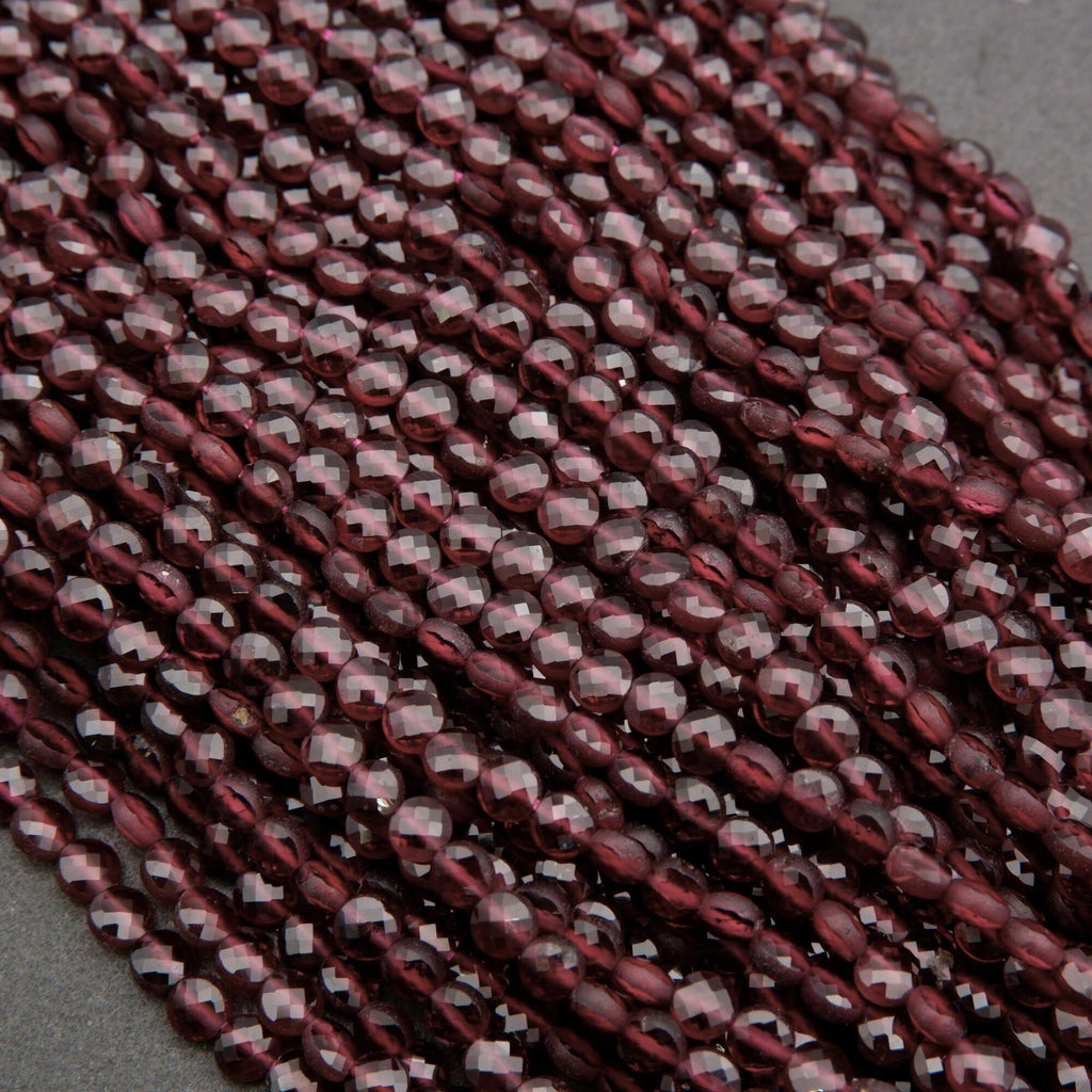 Close-up of a string of maroon beads on a gray surface