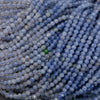 Close-up of blue beads with a green bead amidst them