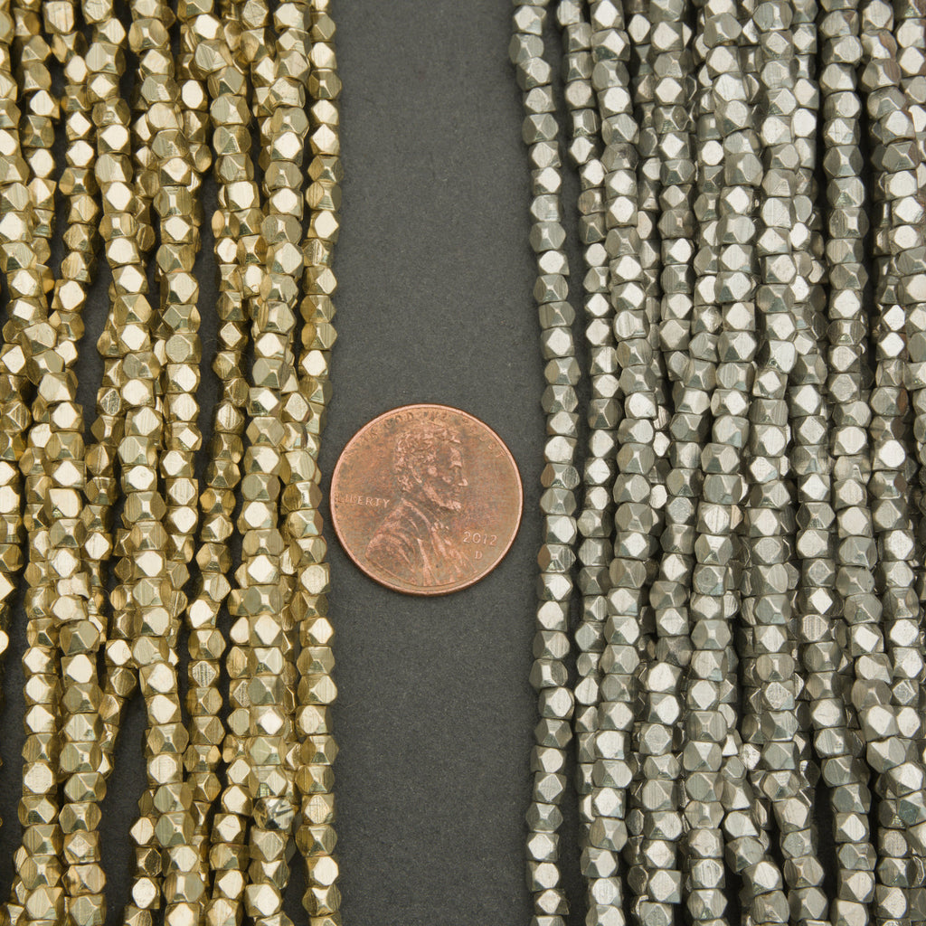 Two strands of faceted beads with a penny for scale on a dark background