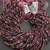 Multicolored bead strands with pink string on a gray background