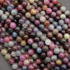 Round ruby and sapphire gemstone beads in mixed red, pink, blue, and grey tones