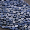 Close-up of blue oval beads on a dark background