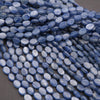Close-up of blue oval beads on a gray surface