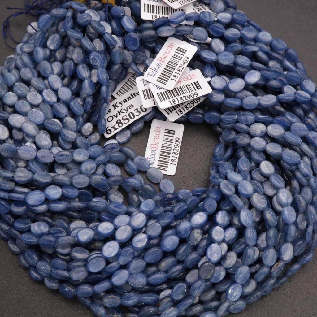 Blue oval beads on a string with visible barcodes on a dark background