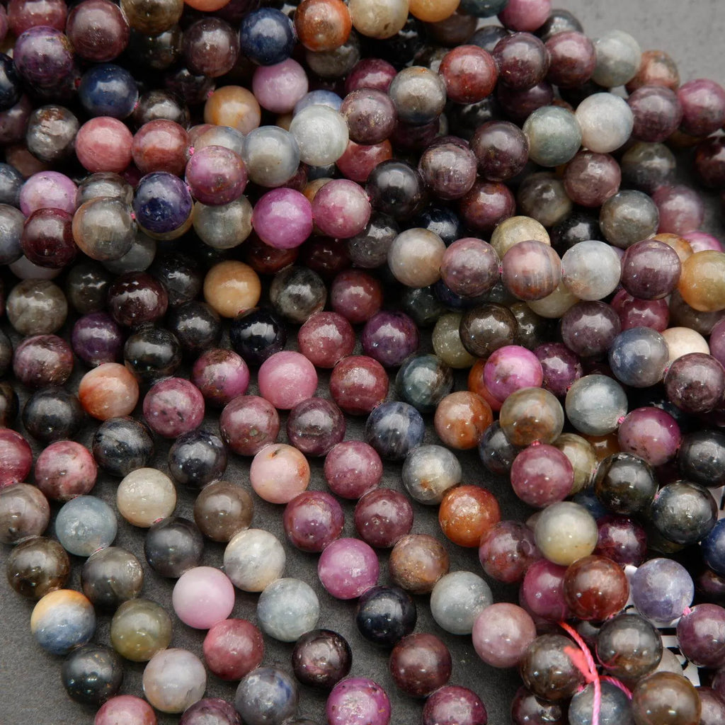 8mm round ruby and sapphire beads showing deep jewel tones and silky matrix patterns