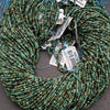 Green beaded strands with price tags on a gray surface
