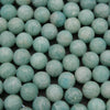 Close-up of teal beads on a black background