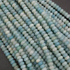 Close-up of light blue and green beads on a dark background