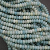 Close-up of light blue and white beads on a dark background