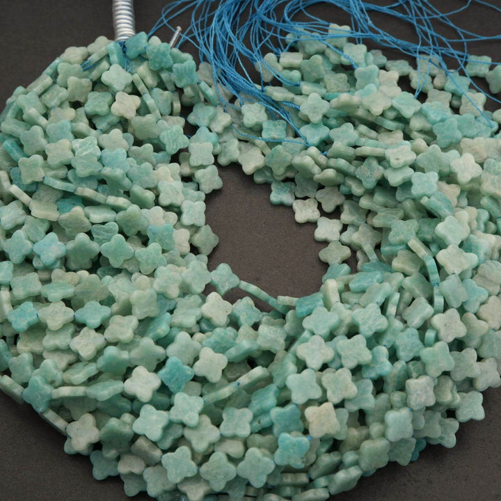 Green flower-shaped beads on a string against a dark background