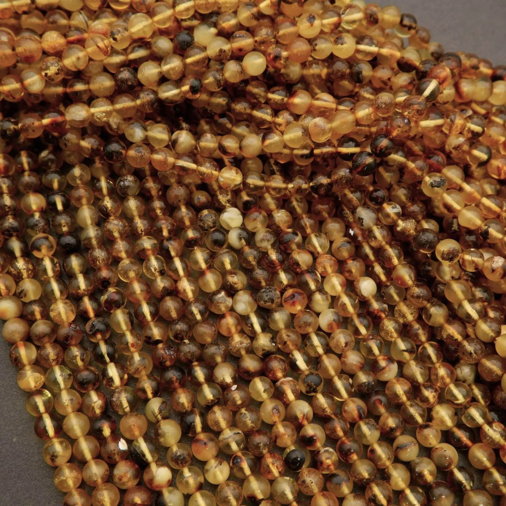 Close-up of amber-colored beads on a string against a gray background