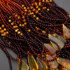 Close-up of a beaded necklace with brown and yellow beads on a dark background