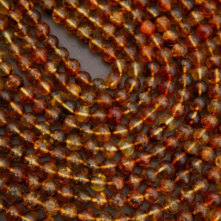 Multiple strands of amber beads arranged together.