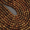 Close-up of a string of metallic brown beads on a gray background