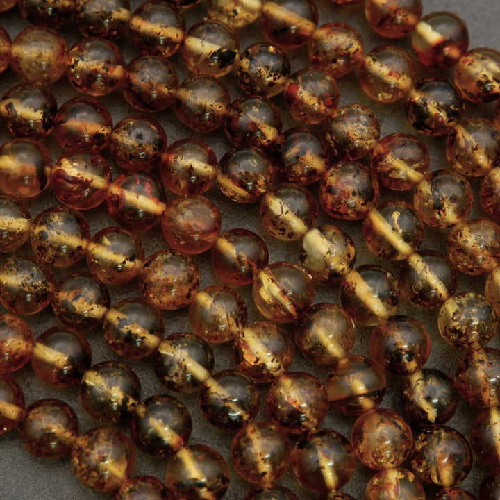 Close-up of amber-colored beads on a textured surface
