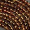 Close-up of amber-colored beads on a textured surface