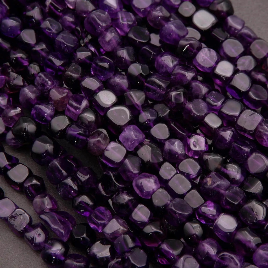 Close-up of purple faceted beads on a gray background