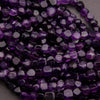 Close-up of purple and white faceted beads on a dark background