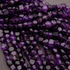Close-up of purple faceted beads on a gray background
