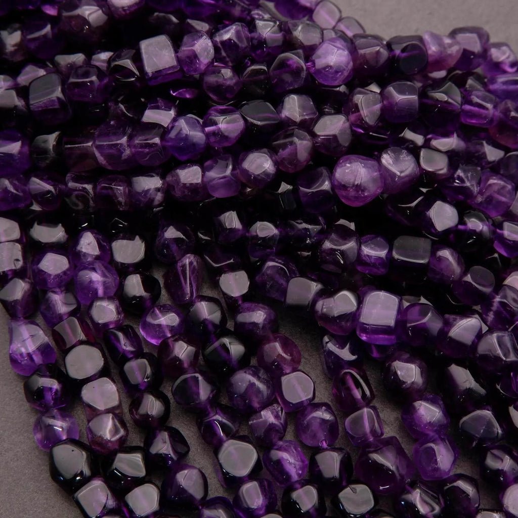 Close-up of purple faceted beads on a gray background