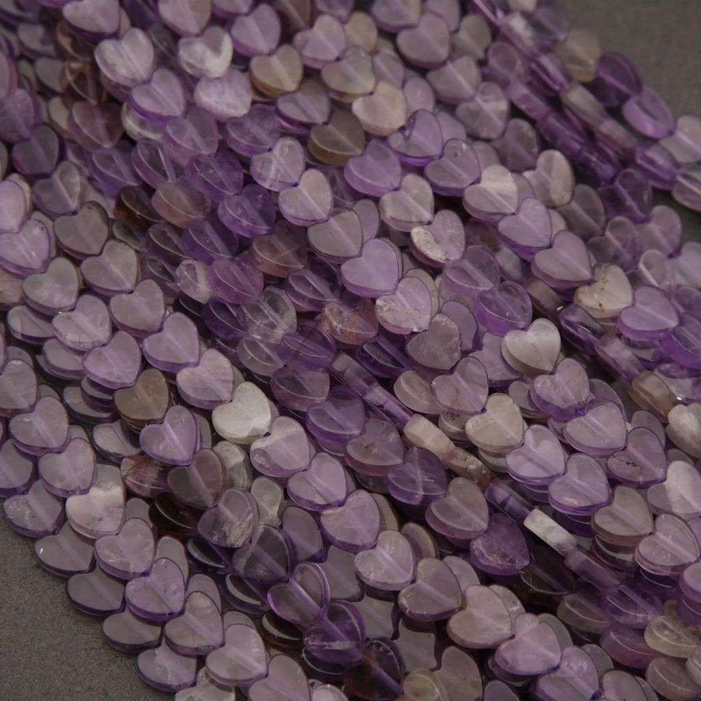 Close-up of purple heart-shaped beads on a gray surface