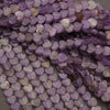 Close-up of purple heart-shaped beads on a gray surface