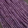 Close-up of purple beads on a gray background