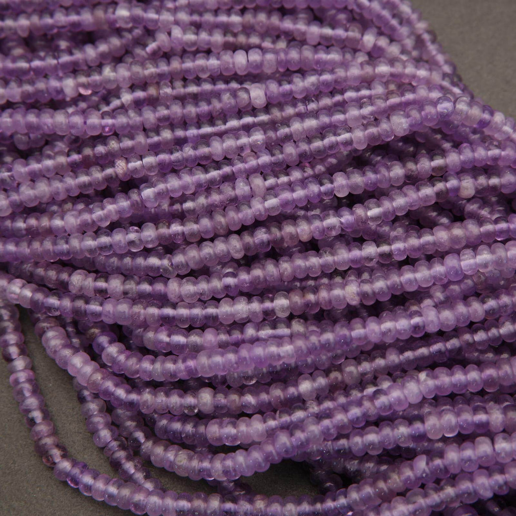 Close-up of a string of purple beads on a gray background