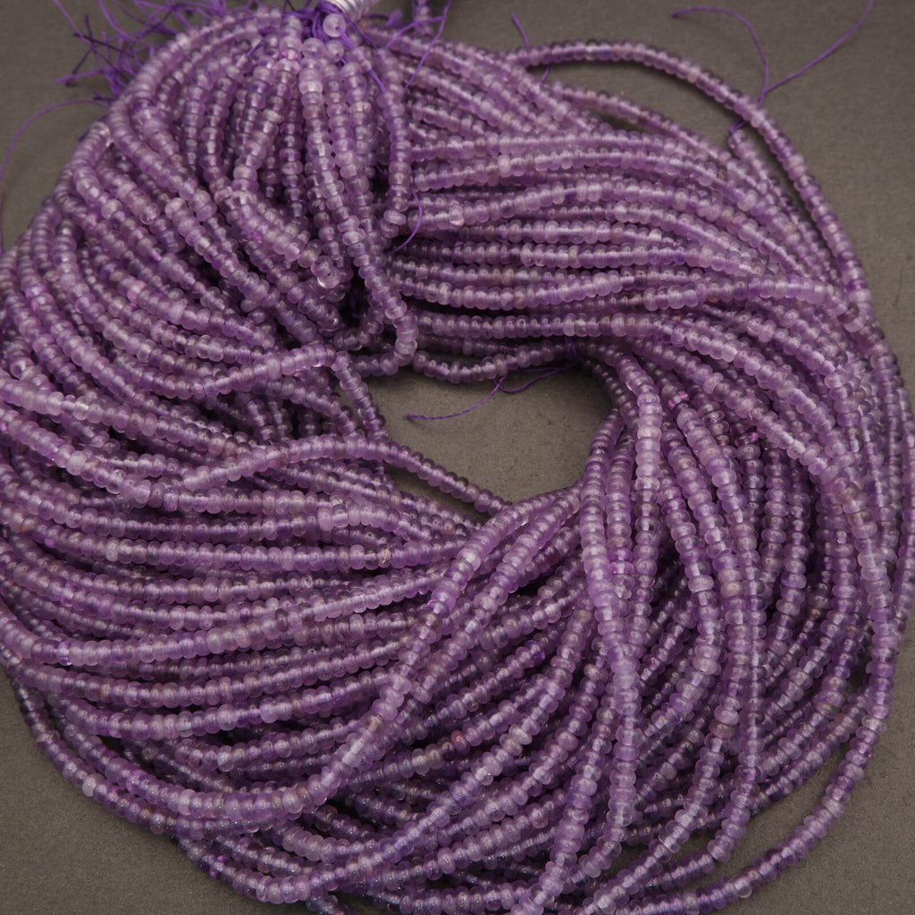 Coiled string of purple beads on a gray background