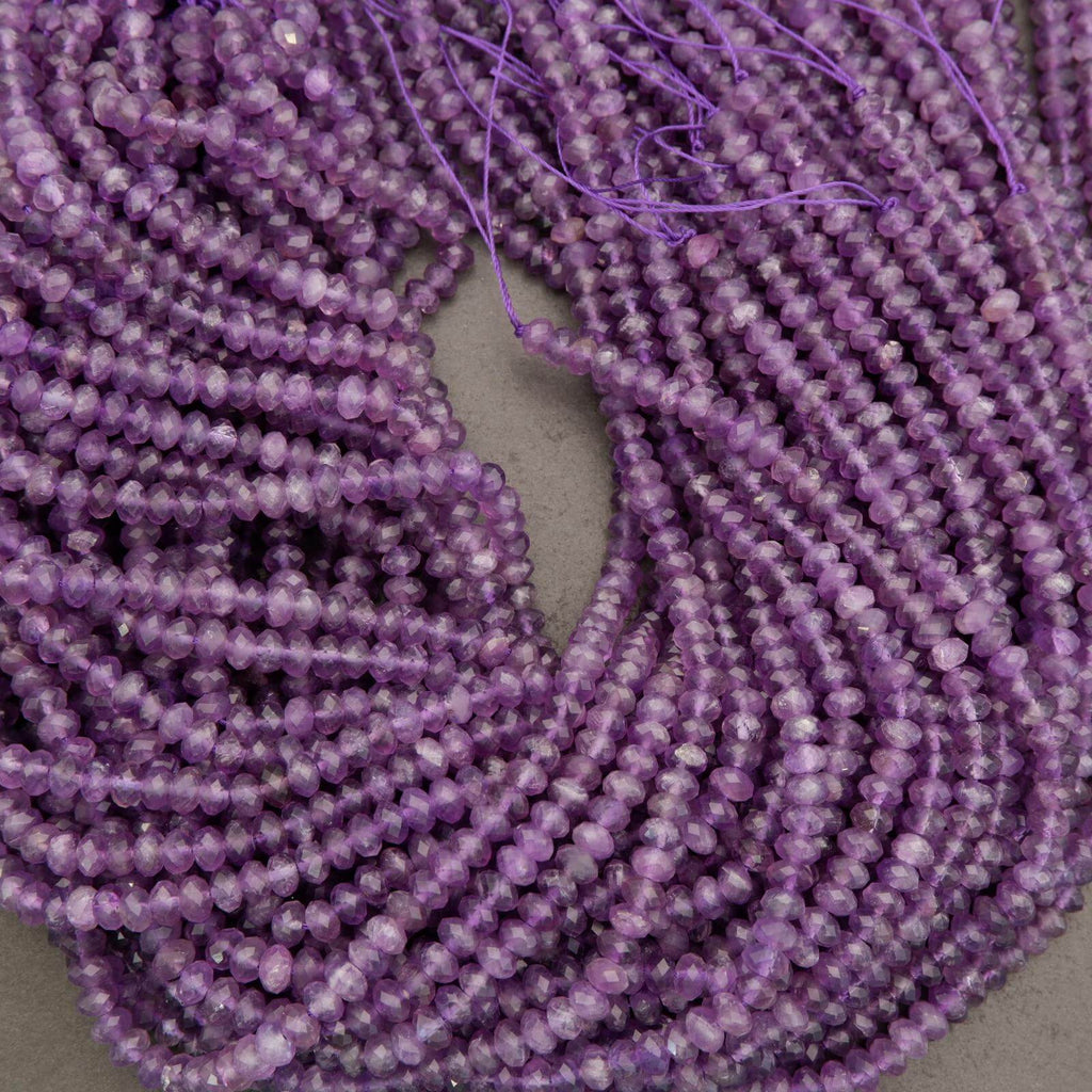 Close-up of a string of purple beads on a light gray background
