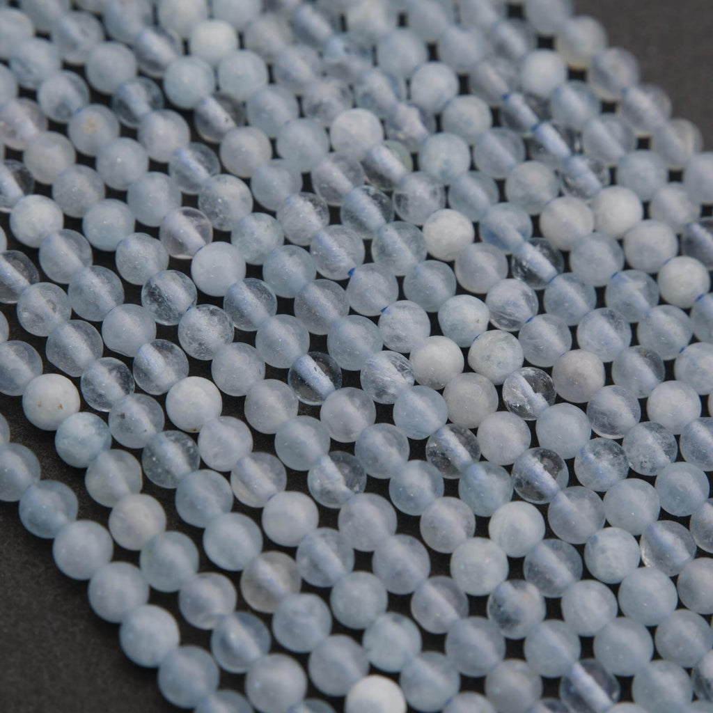 Close-up of light blue beads on a dark surface