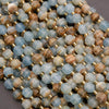 Close-up of a string of multicolored beads with gold spacers on a gray background