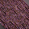 Close-up of a string of small purple beads on a gray background