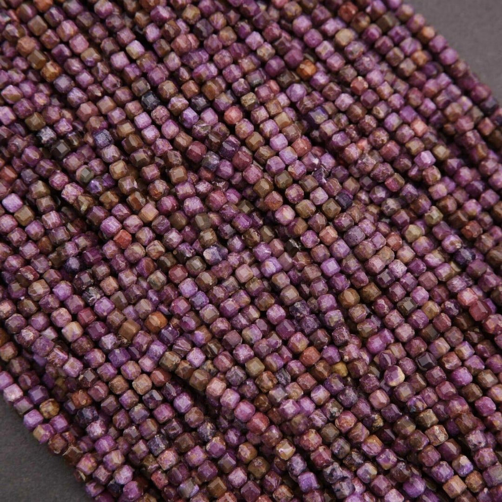 Close-up of a string of small purple beads on a gray background