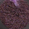 Close-up of a string of purple beads on a dark background