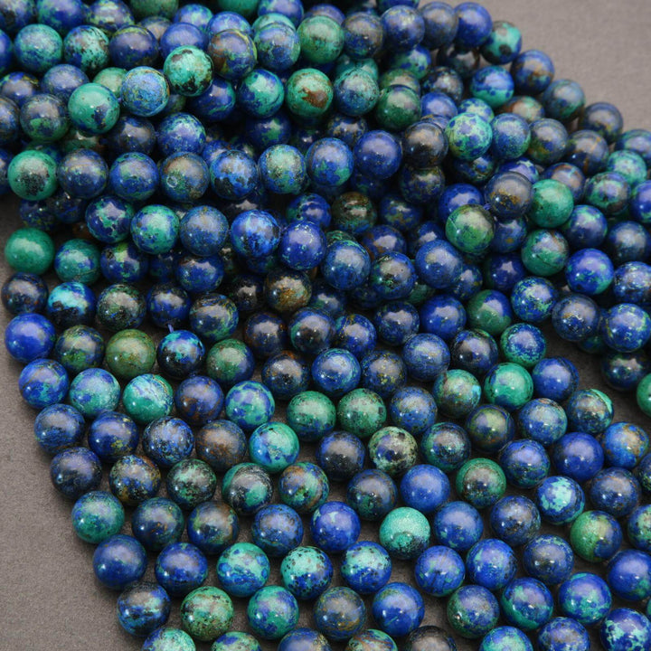 Close-up of blue and green marbled beads on a dark surface