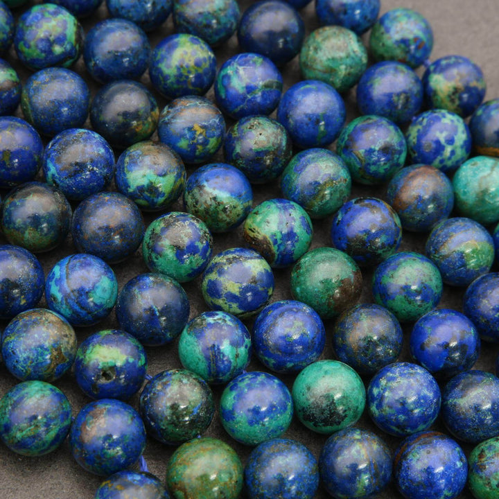 Close-up of blue and green marbled beads on a gray surface