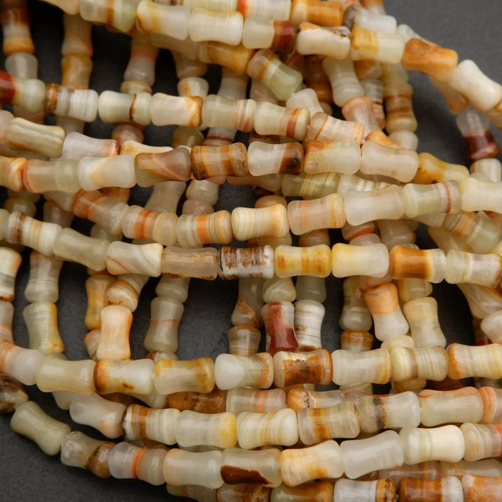 Bamboo-shaped calcite beads in soft green, cream, and honey hues with subtle stripes