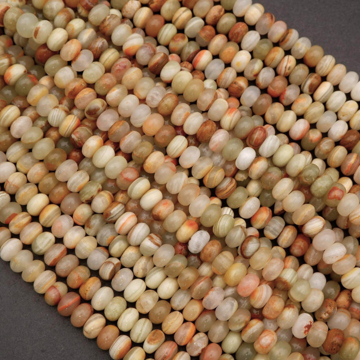 Close-up of green banded calcite rondelle beads showing natural striping and subtle translucency.