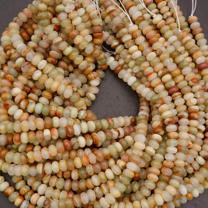 Detail view of green banded calcite beads highlighting soft green hues and earthy banding patterns.