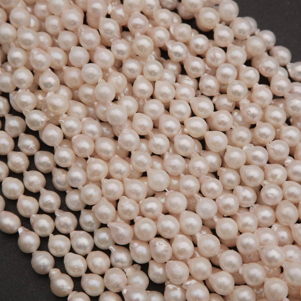 Close-up of a pile of light pink pearls on a dark background