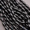 Close-up of black oval beads on a gray background