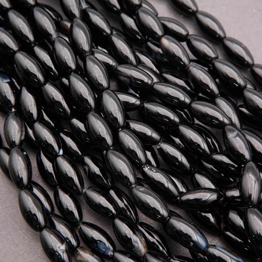 Close-up of black oval beads on a gray background