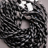 Black beaded necklace with tags on a gray surface