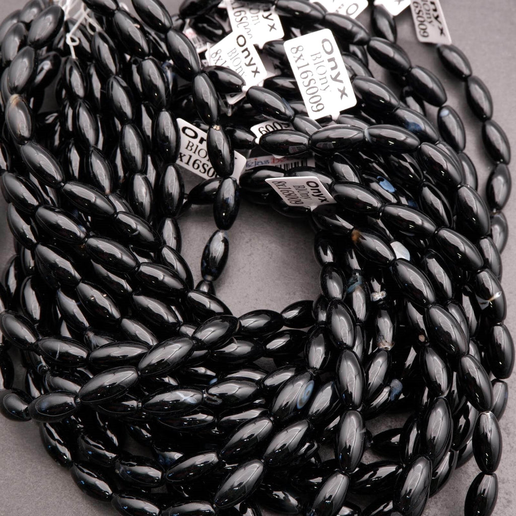 Black beaded necklace with tags on a gray surface