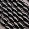 Close-up of black oval beads on a dark surface