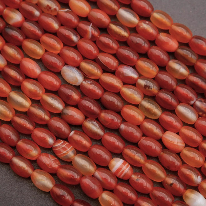 Close-up of red and orange striped beads on a dark background
