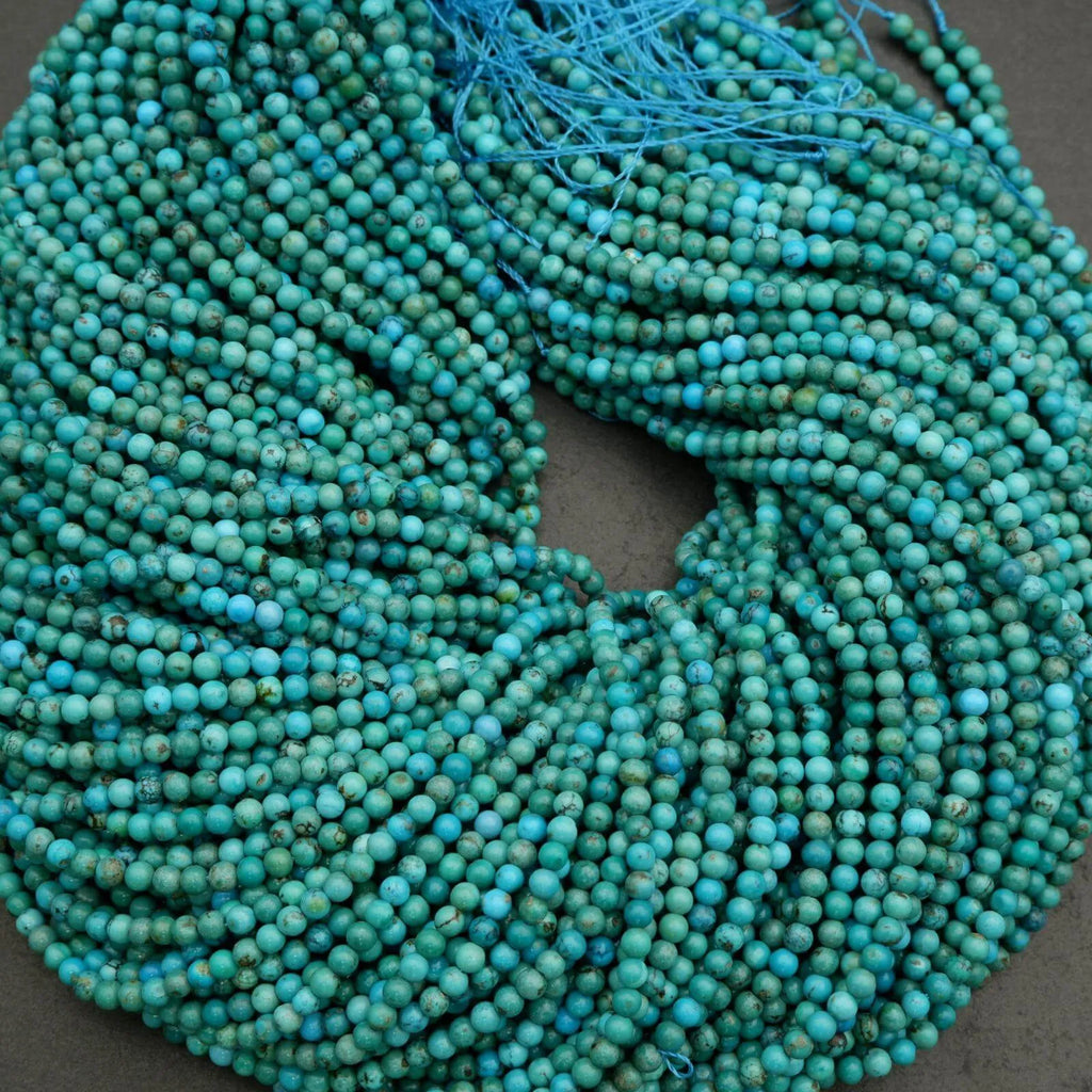 Turquoise beads on a string against a dark background