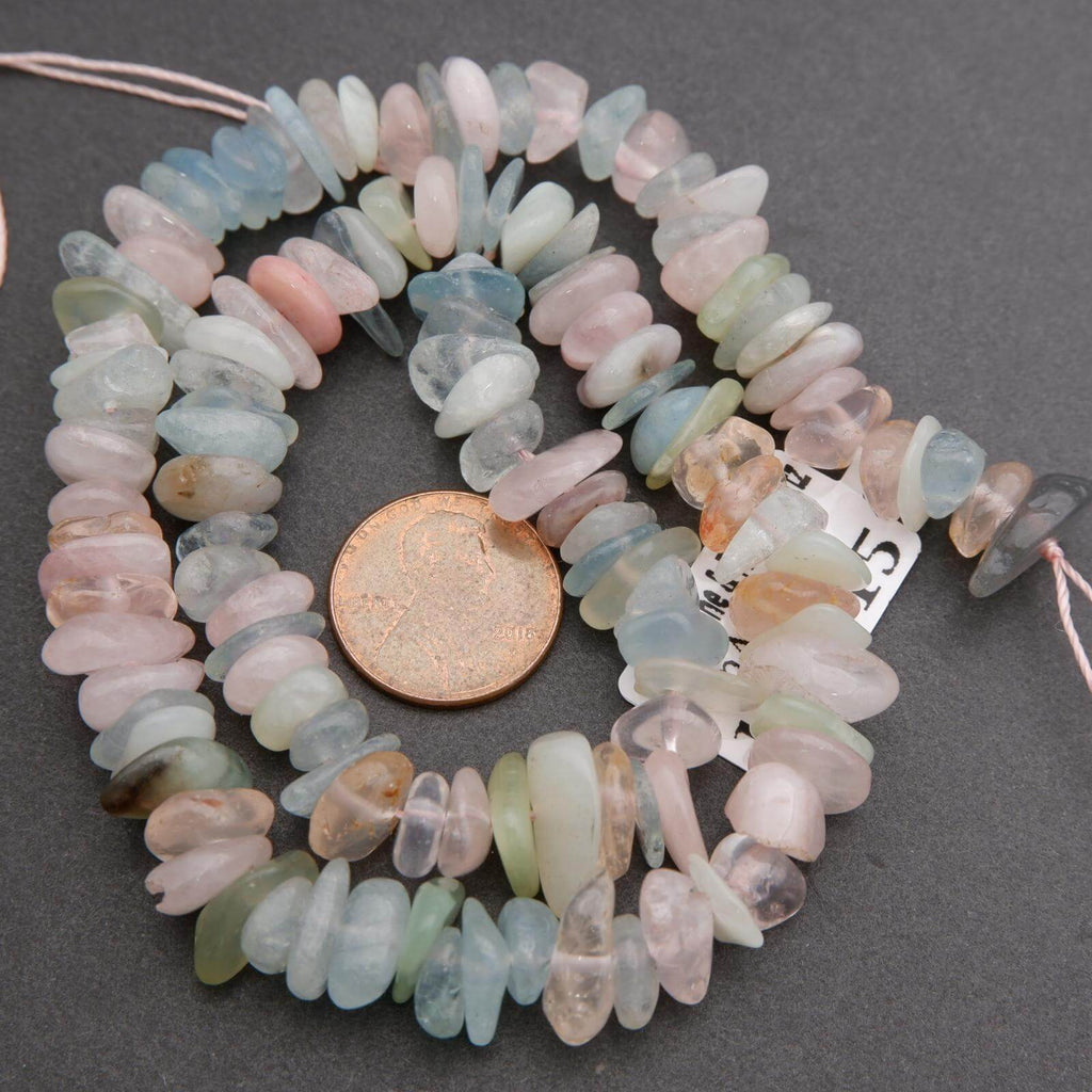 Necklace with multicolored beads and a penny for scale on a gray background